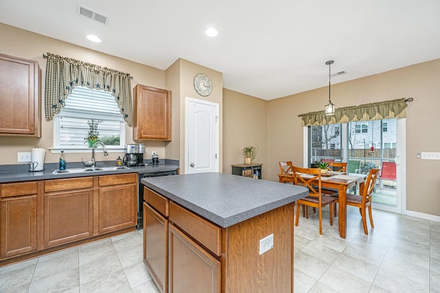 kitchen with visible vents, a kitchen island, a sink, black dishwasher, and dark countertops