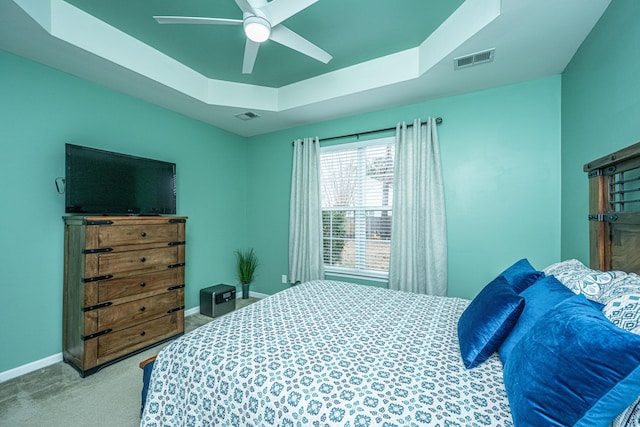 bedroom featuring a raised ceiling, baseboards, visible vents, and carpet floors