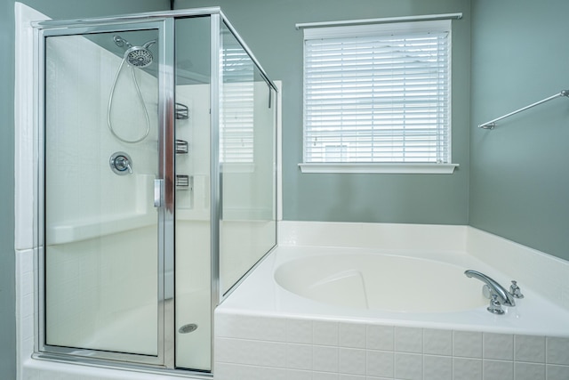 bathroom featuring a bath and a shower stall