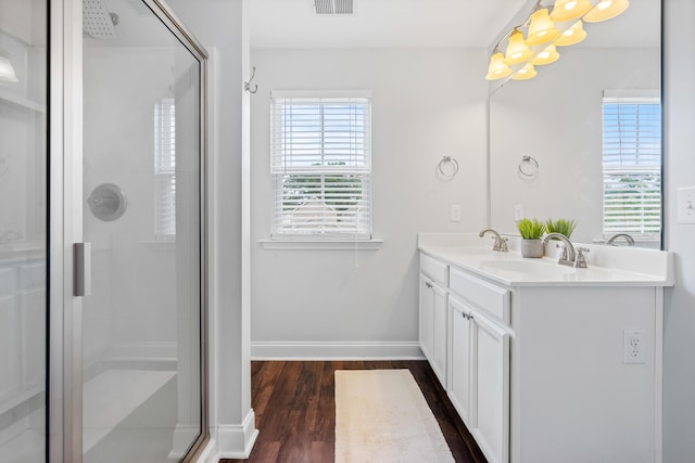 bathroom featuring vanity, a healthy amount of sunlight, hardwood / wood-style floors, and a shower with shower door