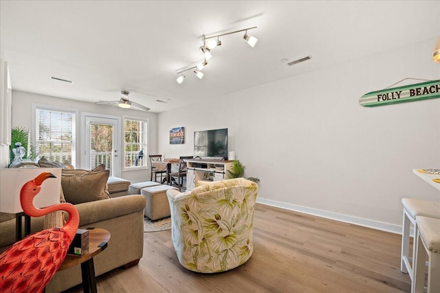 living room with ceiling fan, track lighting, and light hardwood / wood-style floors