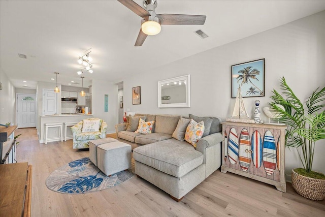 living room featuring ceiling fan and light hardwood / wood-style flooring