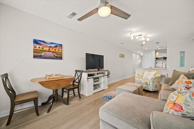 living room featuring ceiling fan and light wood-type flooring