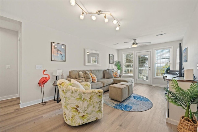 living room with ceiling fan and light wood-type flooring