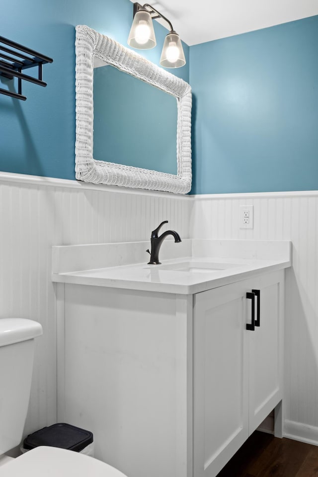 bathroom featuring vanity, wood-type flooring, and toilet