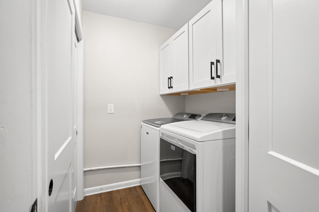 laundry area featuring cabinets, dark wood-type flooring, and washing machine and clothes dryer