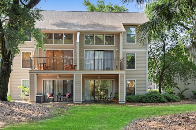 back of property featuring a lawn and a balcony