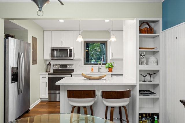 kitchen with sink, appliances with stainless steel finishes, decorative light fixtures, dark hardwood / wood-style flooring, and white cabinetry