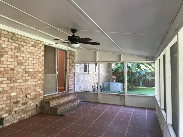 unfurnished sunroom with entry steps and a ceiling fan