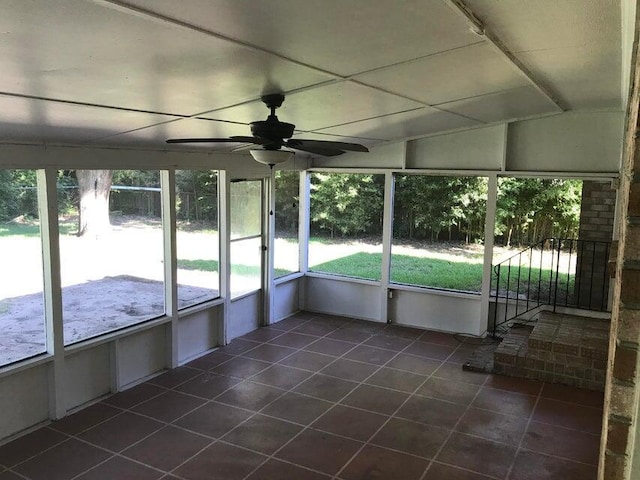 unfurnished sunroom featuring a ceiling fan