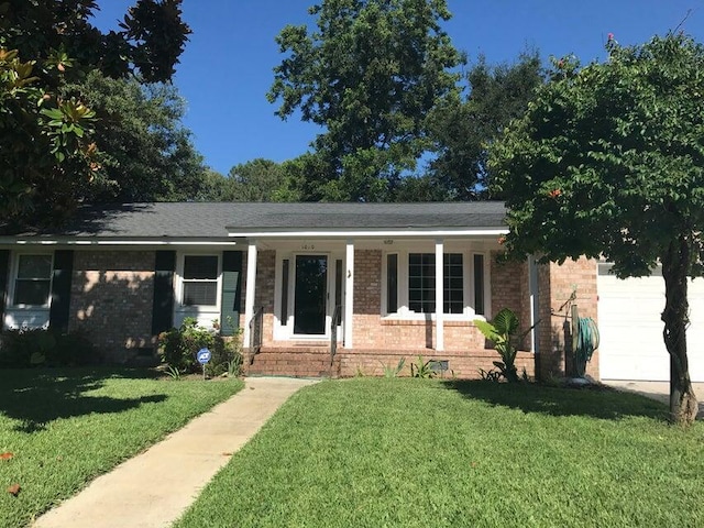 ranch-style home with brick siding, covered porch, a garage, and a front yard