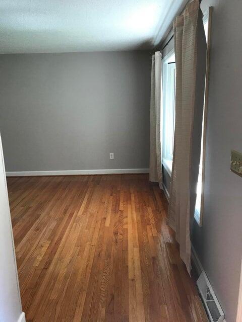 empty room with wood finished floors and baseboards
