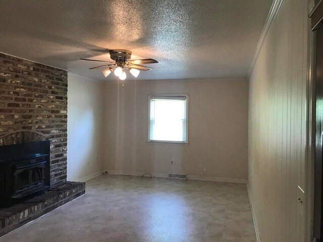 unfurnished living room featuring tile patterned floors, ceiling fan, a textured ceiling, baseboards, and crown molding
