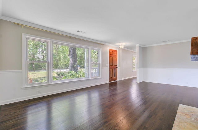 unfurnished living room with baseboards, visible vents, dark wood-type flooring, and crown molding