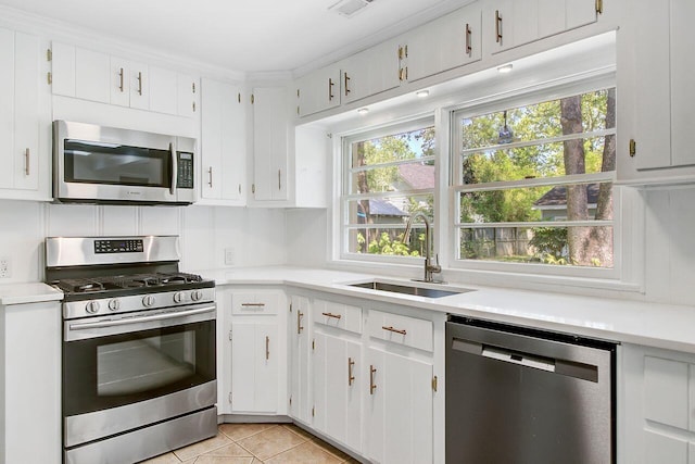 kitchen featuring white cabinets, stainless steel appliances, light countertops, light tile patterned floors, and a sink