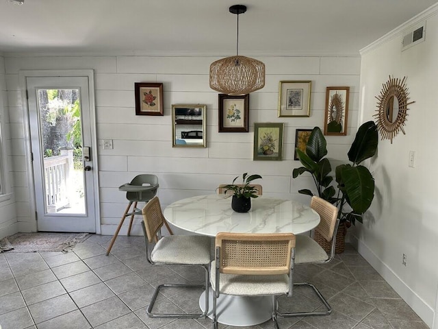 tiled dining area with visible vents, baseboards, and ornamental molding