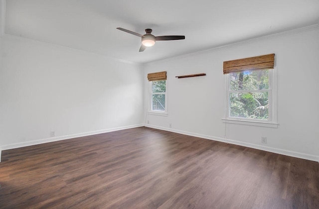 empty room featuring dark wood-type flooring, ceiling fan, baseboards, and ornamental molding