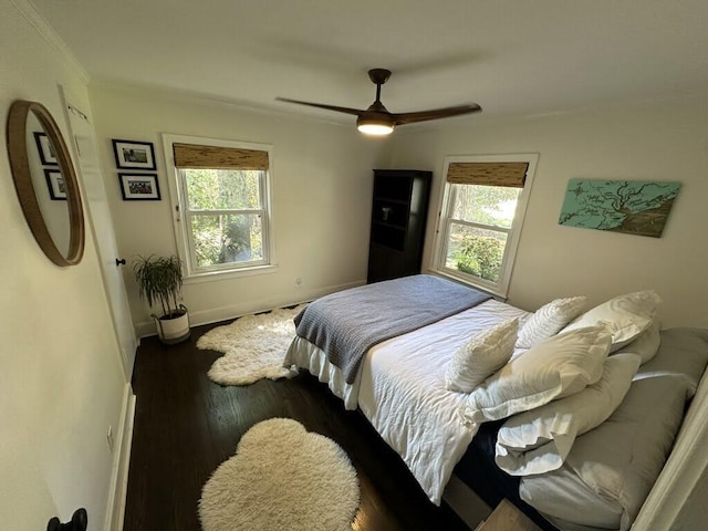 bedroom with ornamental molding, ceiling fan, and dark wood-style flooring
