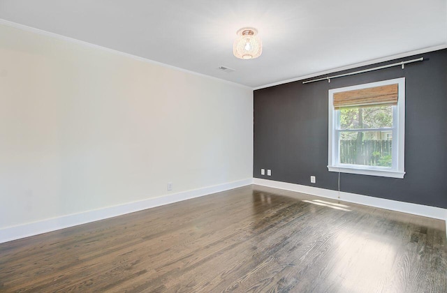 unfurnished room with dark wood finished floors, baseboards, crown molding, and visible vents
