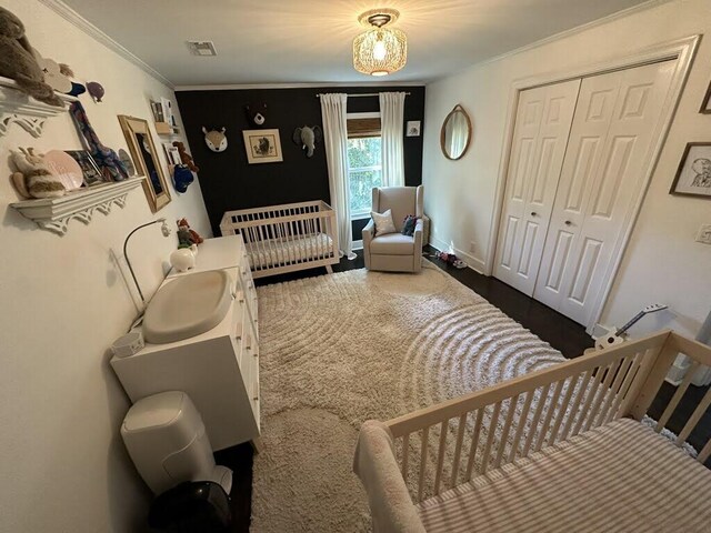 bedroom with visible vents, a closet, and ornamental molding