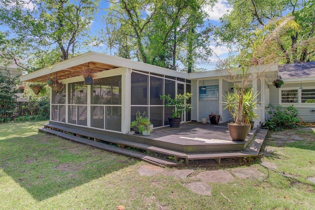back of house featuring a yard, a sunroom, and a deck