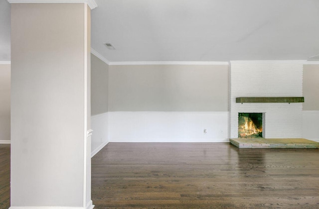 unfurnished living room featuring wood finished floors, a fireplace, baseboards, ornamental molding, and visible vents