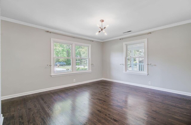 unfurnished room with a wealth of natural light, ornamental molding, a chandelier, and visible vents