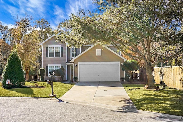 traditional-style home with a garage, driveway, fence, and a front yard