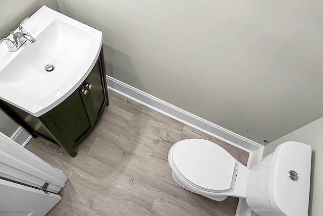 bathroom featuring vanity, toilet, and baseboards