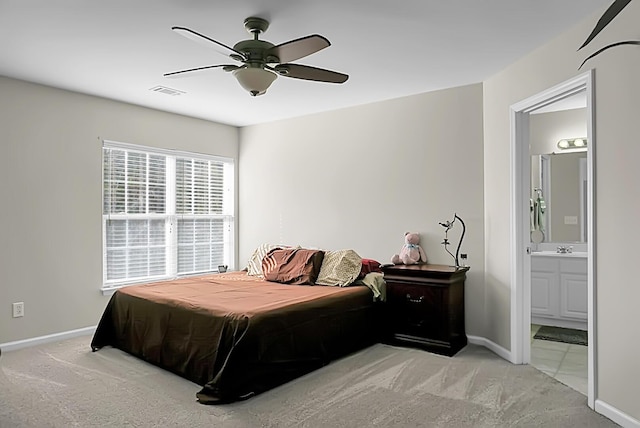 carpeted bedroom with a sink, connected bathroom, baseboards, and a ceiling fan