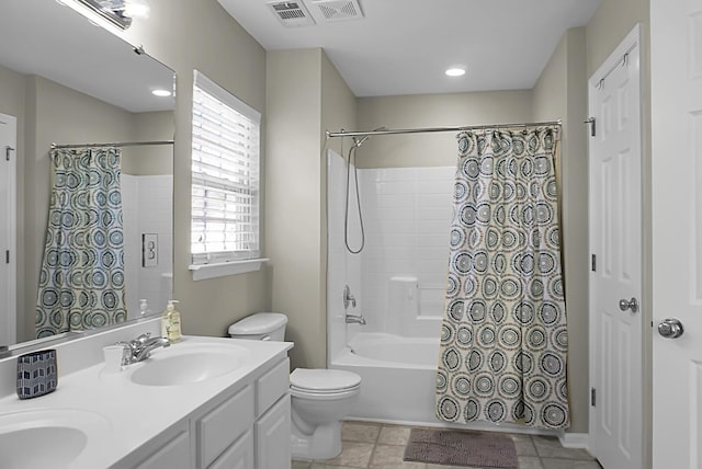 full bathroom featuring double vanity, visible vents, toilet, shower / bath combo with shower curtain, and a sink