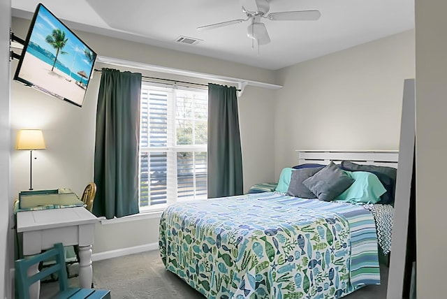 carpeted bedroom with a ceiling fan, visible vents, and baseboards