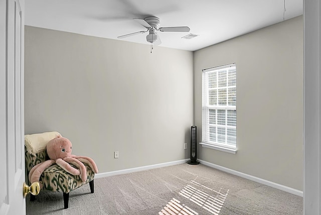 interior space with light carpet, baseboards, visible vents, and a ceiling fan