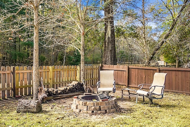 view of yard featuring a fenced backyard and a fire pit