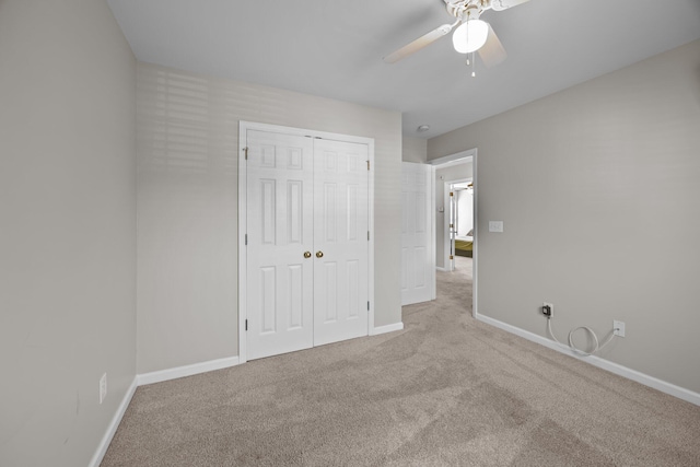 unfurnished bedroom featuring a closet, carpet flooring, a ceiling fan, and baseboards