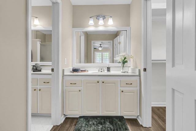 full bathroom with vanity, ceiling fan, and wood finished floors
