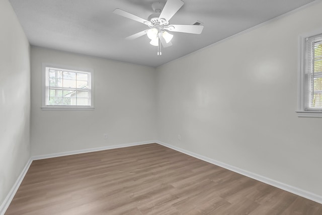 empty room with baseboards, plenty of natural light, and wood finished floors