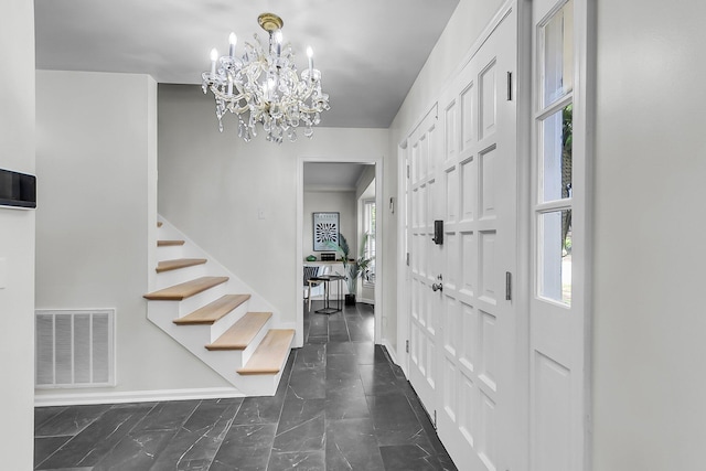 entrance foyer featuring visible vents, marble finish floor, baseboards, stairway, and a notable chandelier