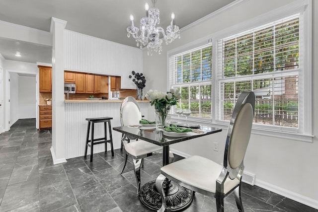 dining space with an inviting chandelier, baseboards, plenty of natural light, and crown molding