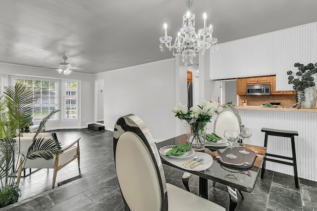 dining area featuring baseboards and ceiling fan with notable chandelier