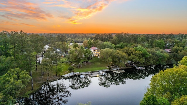 aerial view at dusk featuring a water view