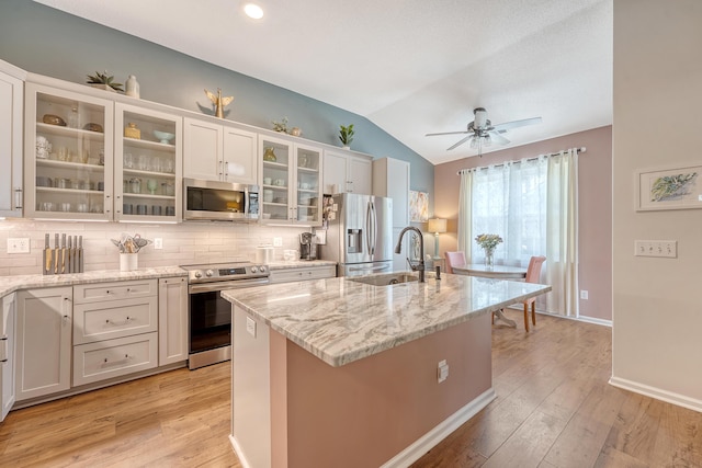 422 Cabrill Dr, Charleston, SC 29414 - kitchen featuring appliances with stainless steel finishes, a sink, vaulted ceiling, light stone countertops, and decorative backsplash
