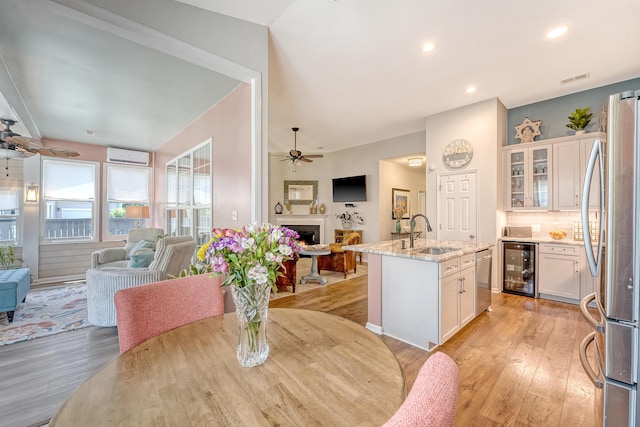 422 Cabrill Dr, Charleston, SC 29414 - dining room with a ceiling fan, wine cooler, a lit fireplace, light wood finished floors, and recessed lighting