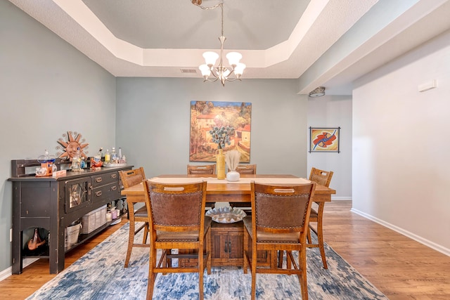 422 Cabrill Dr, Charleston, SC 29414 - dining area featuring a chandelier, a tray ceiling, light wood-type flooring, and baseboards