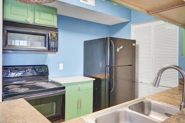 kitchen featuring black appliances, green cabinets, light countertops, and a sink