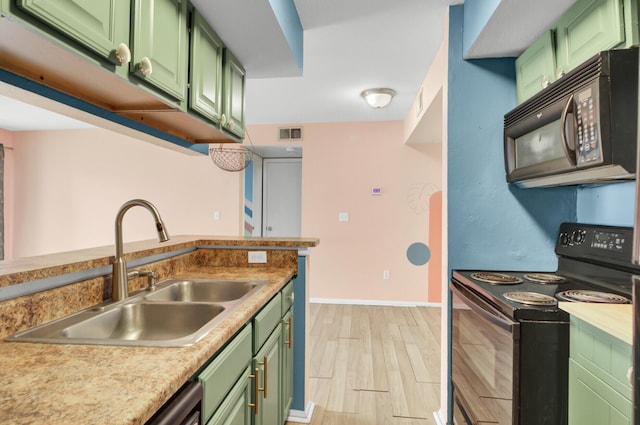 kitchen with visible vents, green cabinetry, light wood-style flooring, black appliances, and a sink