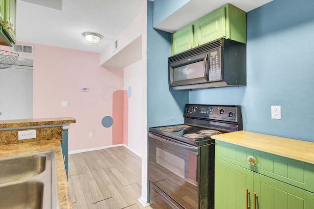 kitchen with visible vents, green cabinets, baseboards, light wood-type flooring, and black appliances