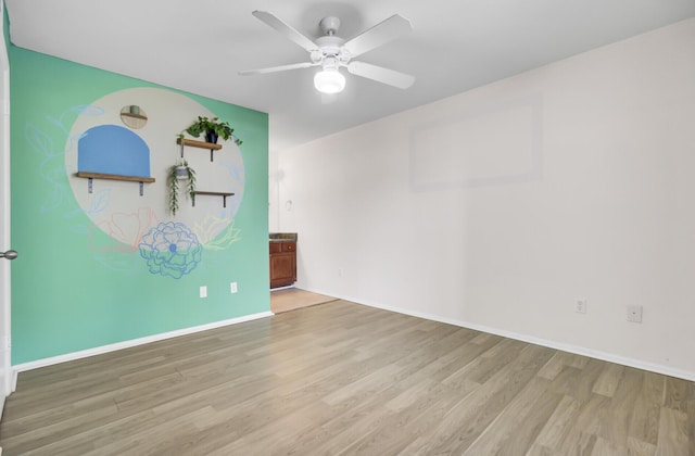 empty room with a ceiling fan, wood finished floors, and baseboards