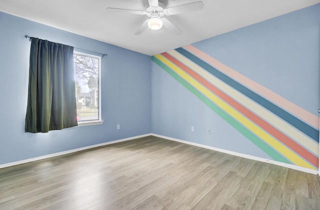 additional living space featuring baseboards, wood finished floors, and a ceiling fan