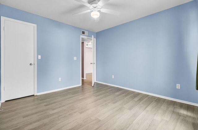 spare room featuring visible vents, baseboards, a ceiling fan, and wood finished floors